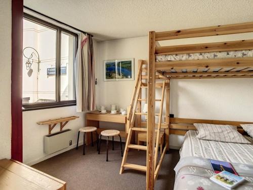 Schlafsaal mit einem Etagenbett und einem Schreibtisch in der Unterkunft Appartement spacieux 6 pers · Proche des pistes · Parking inclus - FR-1-344-750 in Les Menuires