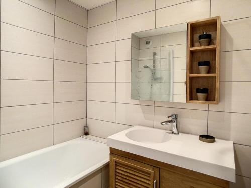 ein Badezimmer mit Waschbecken und Badewanne in der Unterkunft Appartement spacieux 6 pers · Proche des pistes · Parking inclus - FR-1-344-750 in Les Menuires