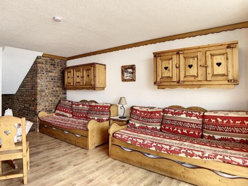 - un salon avec 2 lits et des placards en bois dans l'établissement Studio lumineux, ski aux pieds, balcon sud, 4 pers., 2 Flocons Or - FR-1-344-784, aux Menuires