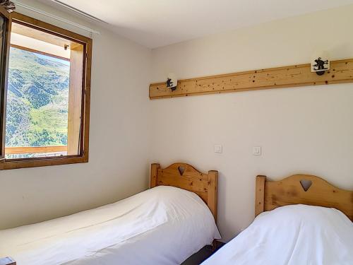 deux lits dans une chambre avec une fenêtre dans l'établissement Appartement spacieux, rénové, proche pistes, balcon, sauna/hammam, WIFI – Résidence Cristaux 1 - FR-1-344-756, à Levassaix