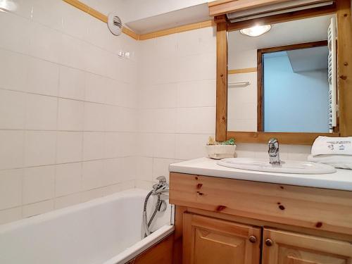 une salle de bain avec un lavabo, une baignoire et un miroir dans l'établissement Appartement spacieux, rénové, proche pistes, balcon, sauna/hammam, WIFI – Résidence Cristaux 1 - FR-1-344-756, à Levassaix
