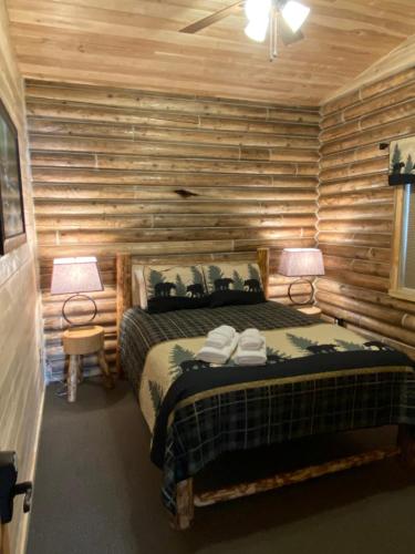 a bedroom with a bed in a log cabin at Alaska Knotty Pine B&B in Palmer