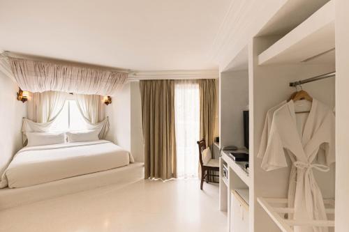 a white bedroom with a bed and a window at At Niman conceptual Home chiangmai in Chiang Mai