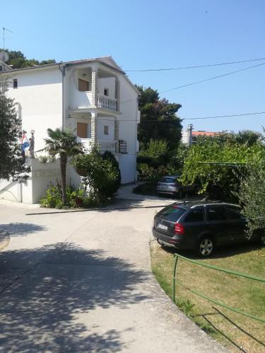 a car parked in front of a white house at Alemka in Banjol