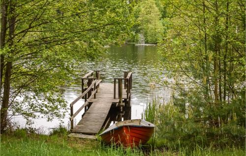 a boat sitting next to a dock on a lake at Nice Home In Olofström With Kitchen in Olofström