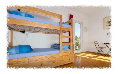 a bedroom with a bunk bed with blue pillows at Hostel Oktarin in Kaštela
