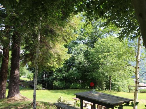a wooden picnic table with a red flower on it at Holiday Home in Cison with Mountain Views in Cison di Valmarino