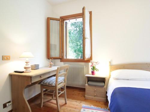 a bedroom with a desk and a bed and a window at Holiday Home in Cison with Mountain Views in Cison di Valmarino