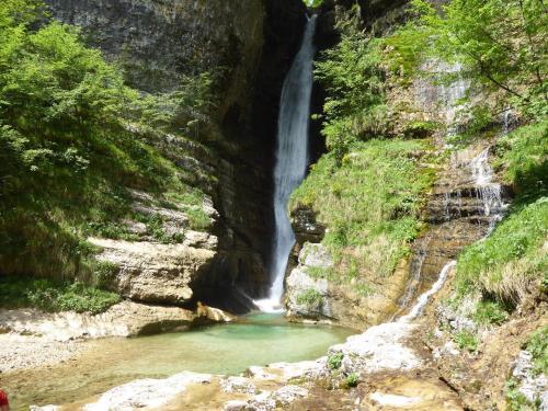 a waterfall in a canyon next to a river at Holiday Home in Cison with Mountain Views in Cison di Valmarino
