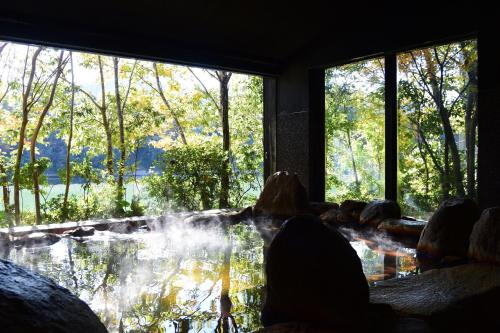 a room with a large window looking out at a pond at Kohanyu in Kami