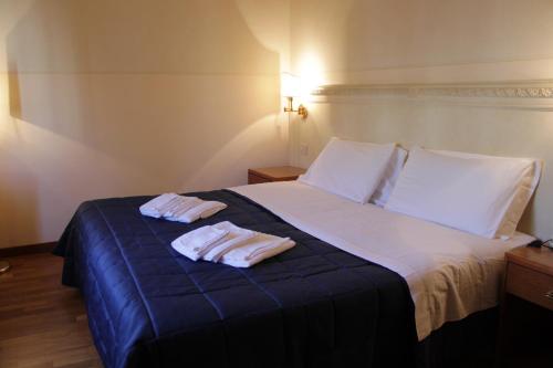 a hotel room with two towels on a bed at Hotel Posta in Cecina