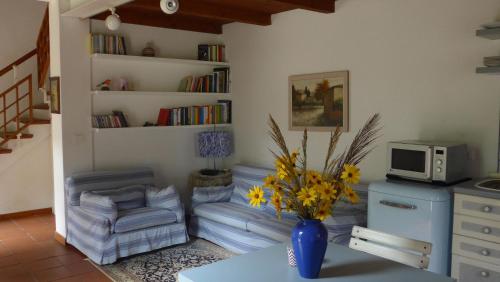 sala de estar con mesa y jarrón con flores en Villa Resta & Dependance en Castel San Pietro Terme