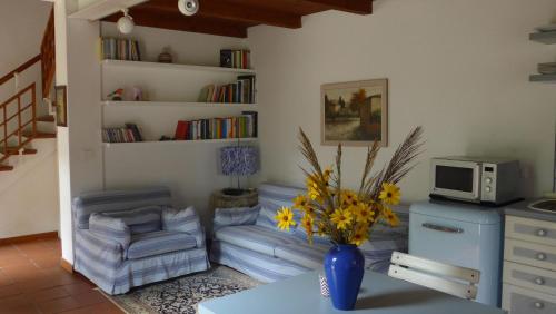 a living room with a table and a vase with flowers at Villa Resta & Dependance in Castel San Pietro Terme