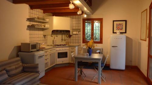 a kitchen with a refrigerator and a table in it at Villa Resta & Dependance in Castel San Pietro Terme