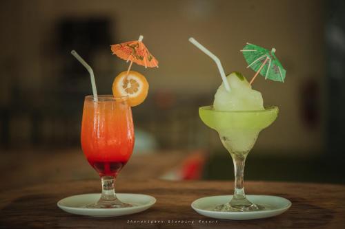 two cocktails sitting on plates on a table at Shenanigans Glamping Resort in Zamboanguita