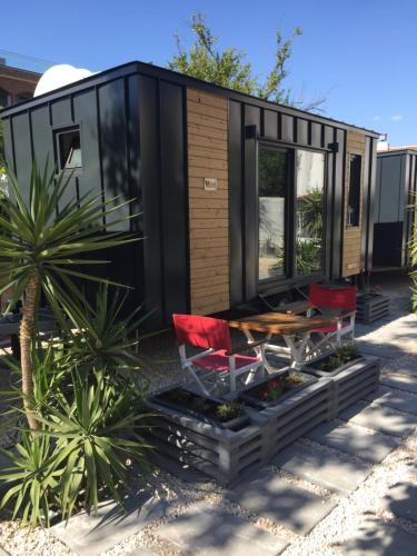 a black tiny house with red chairs and a table at Hotel Barba in Urla