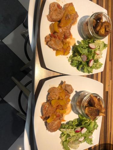 two plates of food with meat and salad on them at Au Domaine Fresnois in Fresnes-lès-Montauban