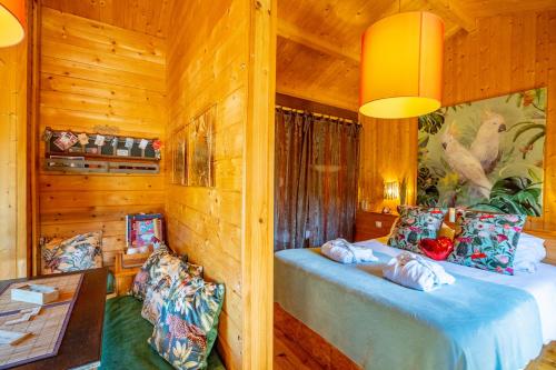 a bedroom with two beds in a log cabin at Le Bassin du Tertre in Fronsac