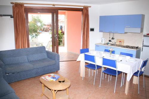 a living room with a couch and a table and a kitchen at Porto Antigo Two Bed Apartment with Sea View in Santa Maria