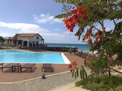 a swimming pool with a view of the ocean at Porto Antigo Two Bed Apartment with Sea View in Santa Maria