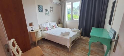 um pequeno quarto com uma cama e uma secretária verde em KLADIS HOME em Akrotiri