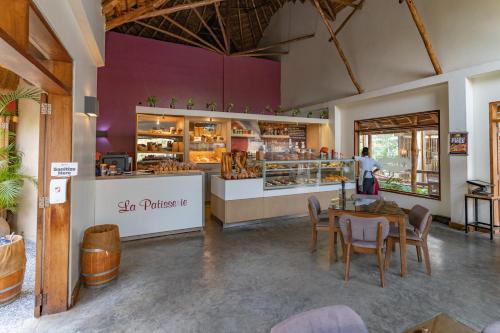 a restaurant with a table and chairs and a bakery at Le Petit Village Boutique Hotel & Spa in Kampala