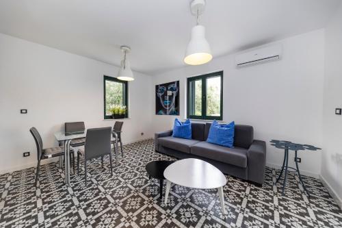 a living room with a couch and a table and chairs at Mama House Villa in Novalja