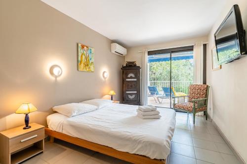 - une chambre avec un lit, une télévision et un balcon dans l'établissement La Viguerie par Dodo-a-Cassis, à Cassis