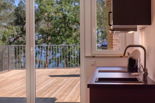 a kitchen with a view of a deck from a balcony at Apartamenty Na Klifie Przystań 18 Chłapowo in Władysławowo
