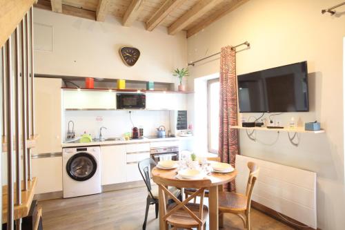 une cuisine et une salle à manger avec une table et des chaises dans l'établissement HOME SAVOIE - Le Cygne, à Annecy