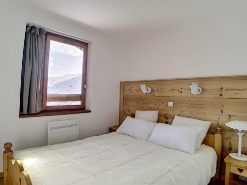 um quarto com uma cama branca e uma janela em Appartement Les Menuires, 3 pièces, 6 personnes - FR-1-344-789 em Les Menuires