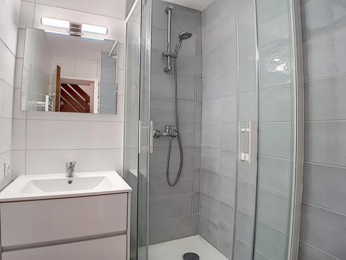 uma casa de banho branca com um chuveiro e um lavatório. em Appartement Les Menuires, 3 pièces, 6 personnes - FR-1-344-789 em Les Menuires