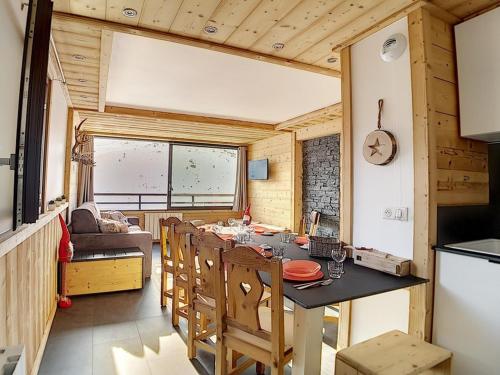 une cuisine et une salle à manger avec une table et des chaises dans l'établissement Charmant Appart 3 pièces avec cabine, skis aux pieds, parking inclus - FR-1-344-796, aux Menuires