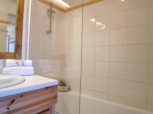 une salle de bain blanche avec une douche et un lavabo dans l'établissement Appartement rénové avec balcon, sauna, hammam et WIFI · Proche des pistes · Hameau des Marmottes - FR-1-344-798, à Levassaix