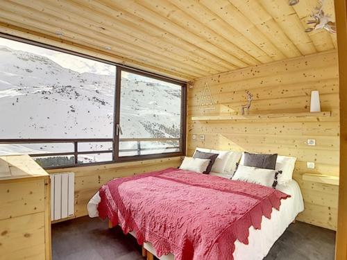 une chambre avec un lit dans une pièce en bois dans l'établissement Charmant Appart 3 pièces avec cabine, skis aux pieds, parking inclus - FR-1-344-796, aux Menuires