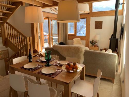 un salon avec une table, des chaises et un canapé dans l'établissement Chalet Aigle · Accès Pistes · Wifi · Jacuzzi · Sauna · Poêle à bois · Parking · 3 Chambres en Suite - FR-1-344-804, à Saint-Martin-de-Belleville