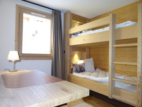 une chambre avec deux lits superposés et une fenêtre dans l'établissement Chalet Aigle · Accès Pistes · Wifi · Jacuzzi · Sauna · Poêle à bois · Parking · 3 Chambres en Suite - FR-1-344-804, à Saint-Martin-de-Belleville