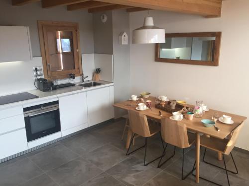 - une cuisine avec une table en bois, des chaises et un évier dans l'établissement Chalet Léa · Ski-in/Ski-out · Wifi Gratuit · Jacuzzi · Sauna · Parking Couvert · 6 Personnes - FR-1-344-803, à Saint-Martin-de-Belleville