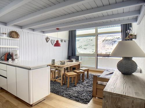 Il comprend une cuisine et une salle à manger avec une table. dans l'établissement Duplex moderne avec balcon, ski aux pieds - FR-1-344-814, aux Menuires