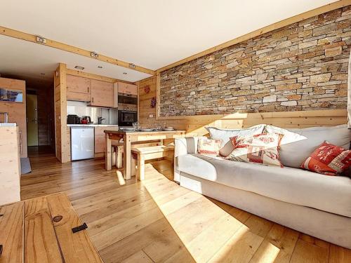 un salon avec un canapé et un mur de briques dans l'établissement Appartement rénové avec 2 balcons, au cœur de la station, proche pistes et commerces - FR-1-344-821, aux Menuires