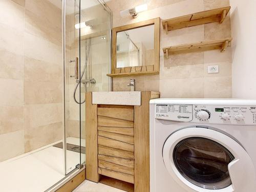 une machine à laver dans une salle de bain avec douche dans l'établissement Appartement rénové avec 2 balcons, au cœur de la station, proche pistes et commerces - FR-1-344-821, aux Menuires