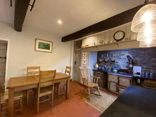 a dining room with a table and a kitchen at Farmhouse Cottage set in beautiful countryside in Oswestry
