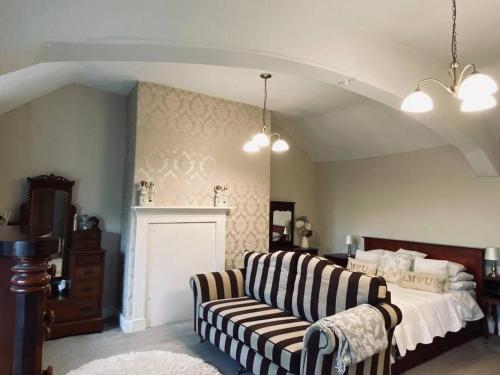 a bedroom with a bed and a couch and a bed at Farmhouse Cottage set in beautiful countryside in Oswestry