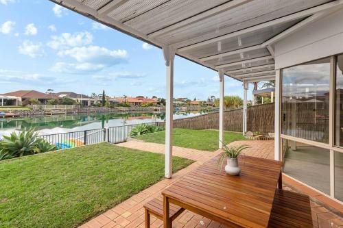 a patio with a wooden bench and a view of the water at Lakeside Haven in Encounter Bay
