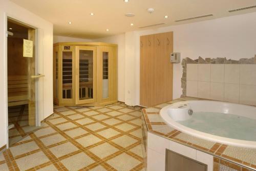 a bathroom with a tub and a tiled floor at The View - Design Panorama Lodge DAS SCHILLER in Bad Gastein