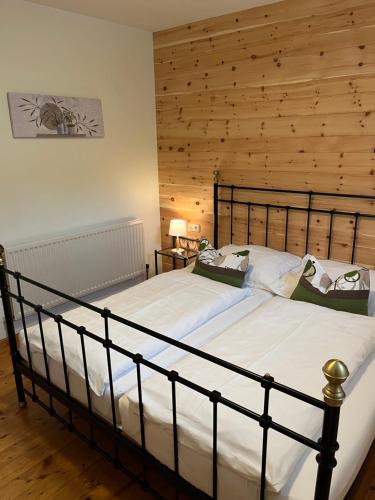 1 dormitorio con 1 cama grande y pared de madera en Ferienwohnung Schmiedhofer, en Ellmau