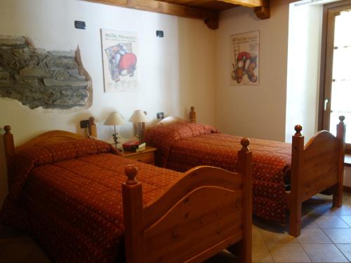 a bedroom with two beds with red comforter at Auberge Lou Créton di Lui Hostel in Pontboset