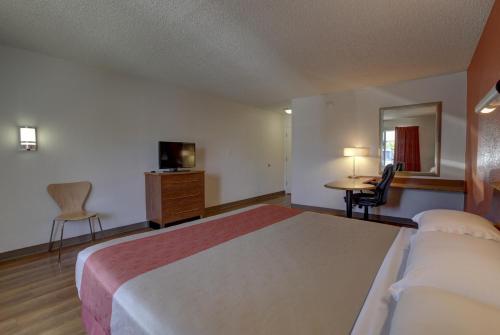 a hotel room with a large bed and a desk at Motel 6-Santa Ana, CA - Irvine - Orange County Airport in Santa Ana