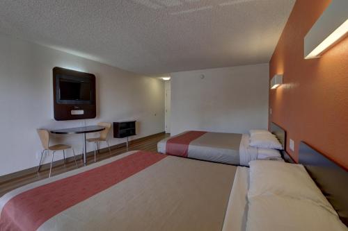 a hotel room with two beds and a tv at Motel 6-Santa Ana, CA - Irvine - Orange County Airport in Santa Ana
