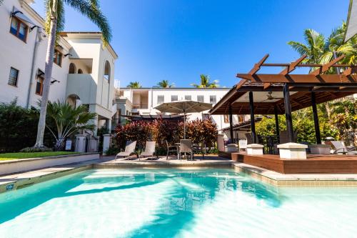 a swimming pool in front of a building at The Mediterranean Port Douglas in Port Douglas